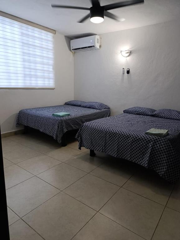 a room with two beds and a ceiling fan at Mercado 28 Residences in Cancún