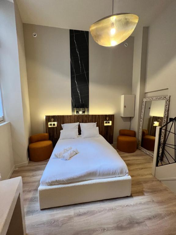 une chambre avec un grand lit blanc avec un miroir dans l'établissement Cocon des Moulins, à Toulouse