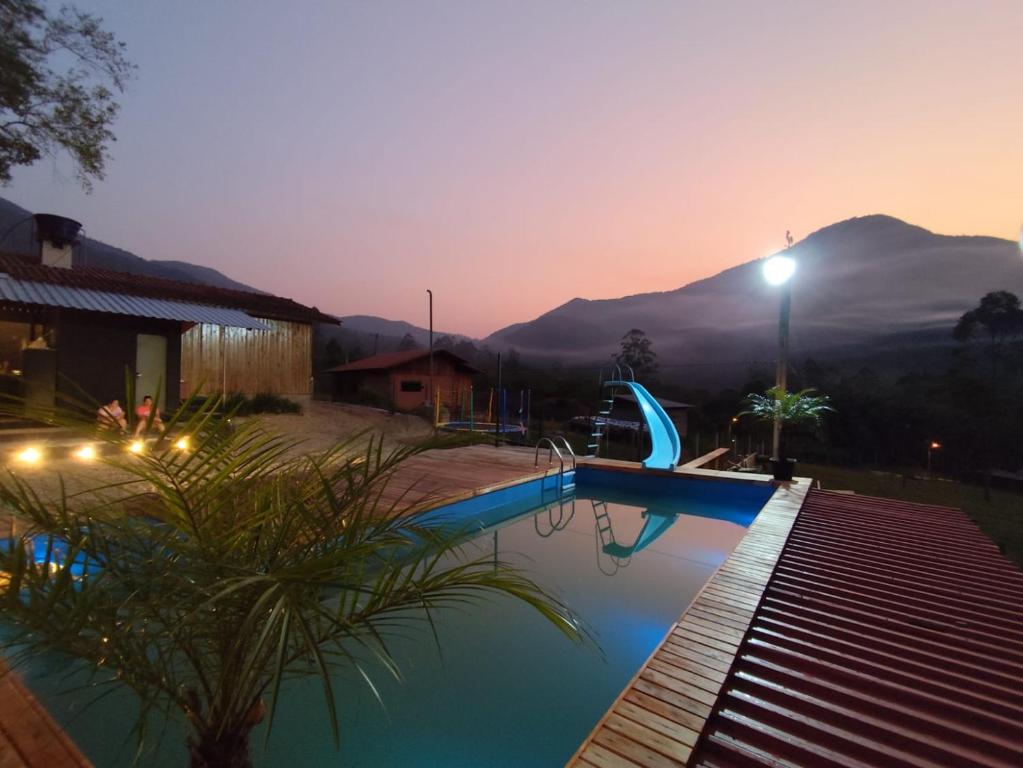 a swimming pool with a view of a mountain at sitio recanto feliz in Canelinha