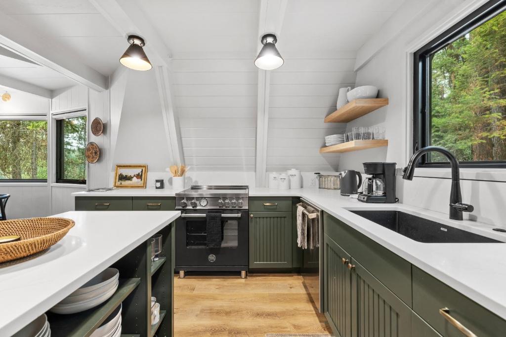 a kitchen with green cabinets and a sink at New! River Cabin A-Frame-Remodeled A-Frame on the river, walk to town, lake & dining in McCall