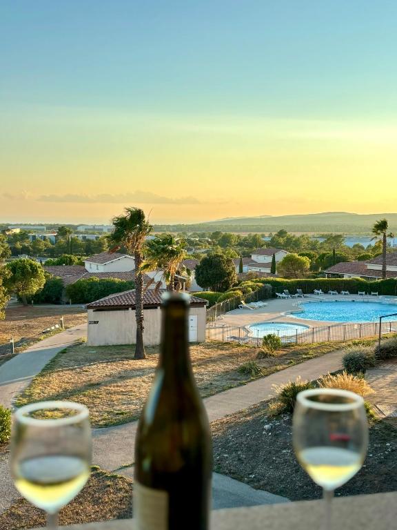 une bouteille de vin posée sur une table avec deux verres dans l'établissement Studio tout confort, à Signes