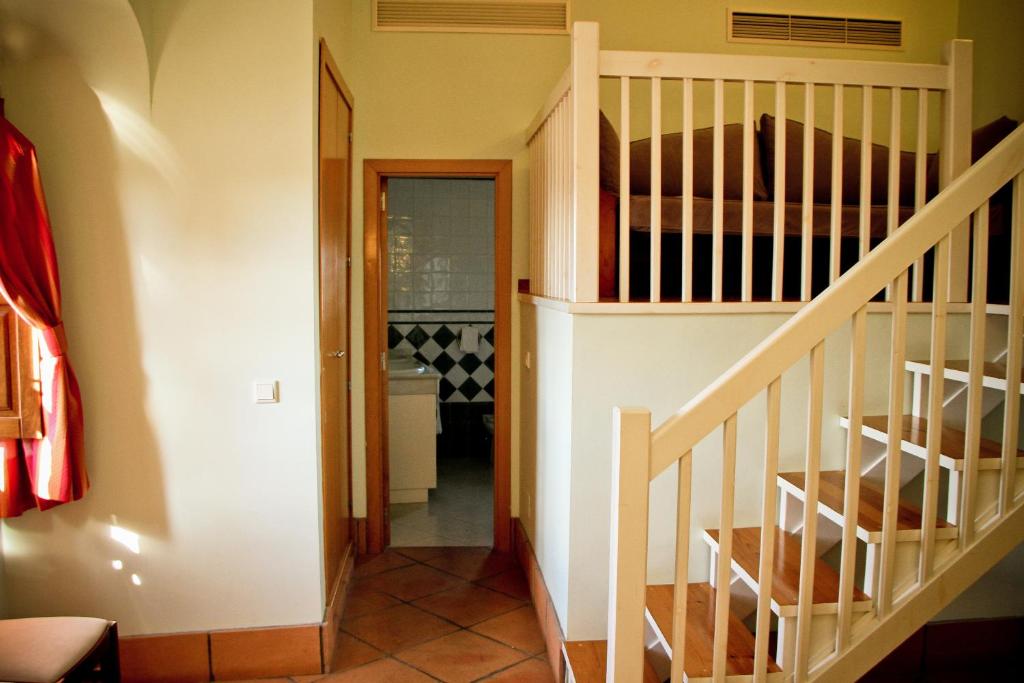 a staircase in a house with a stair case at Hotel Tugasa Castillo de Castellar in Castellar de la Frontera