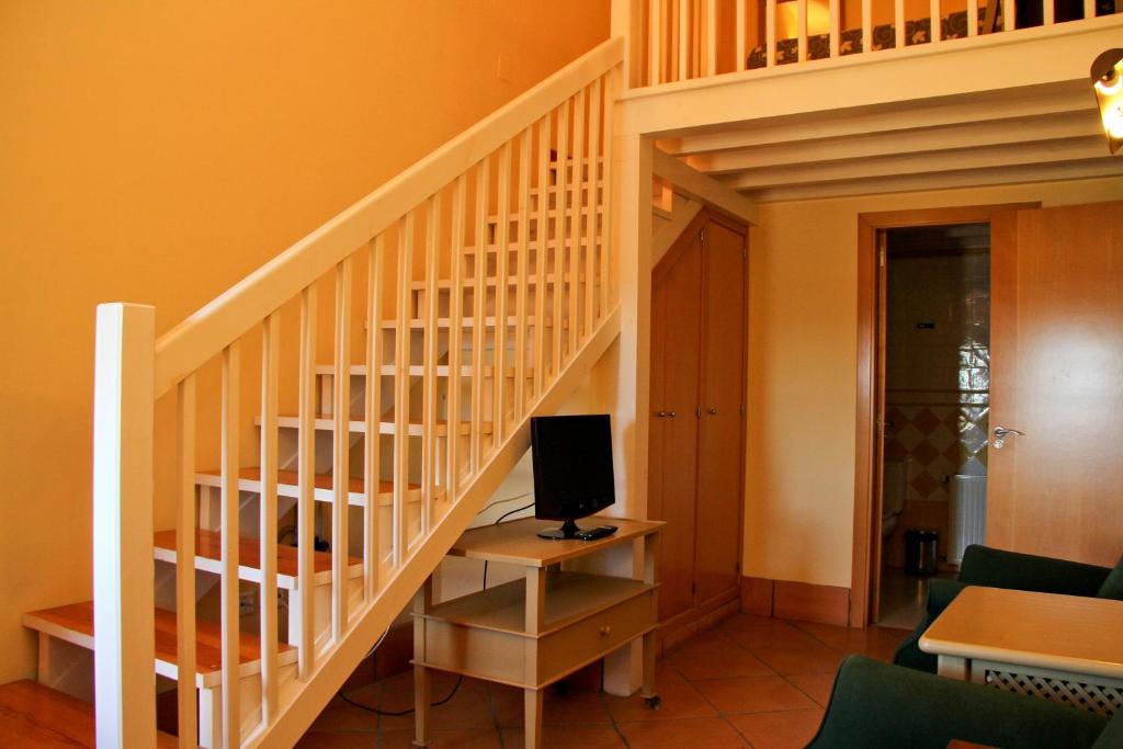 a room with a staircase with a computer on a desk at Hotel Tugasa Castillo de Castellar in Castellar de la Frontera