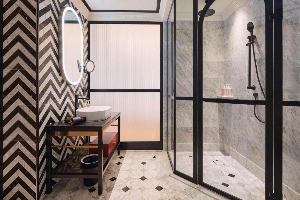 a bathroom with a shower and a sink at QT Singapore in Singapore