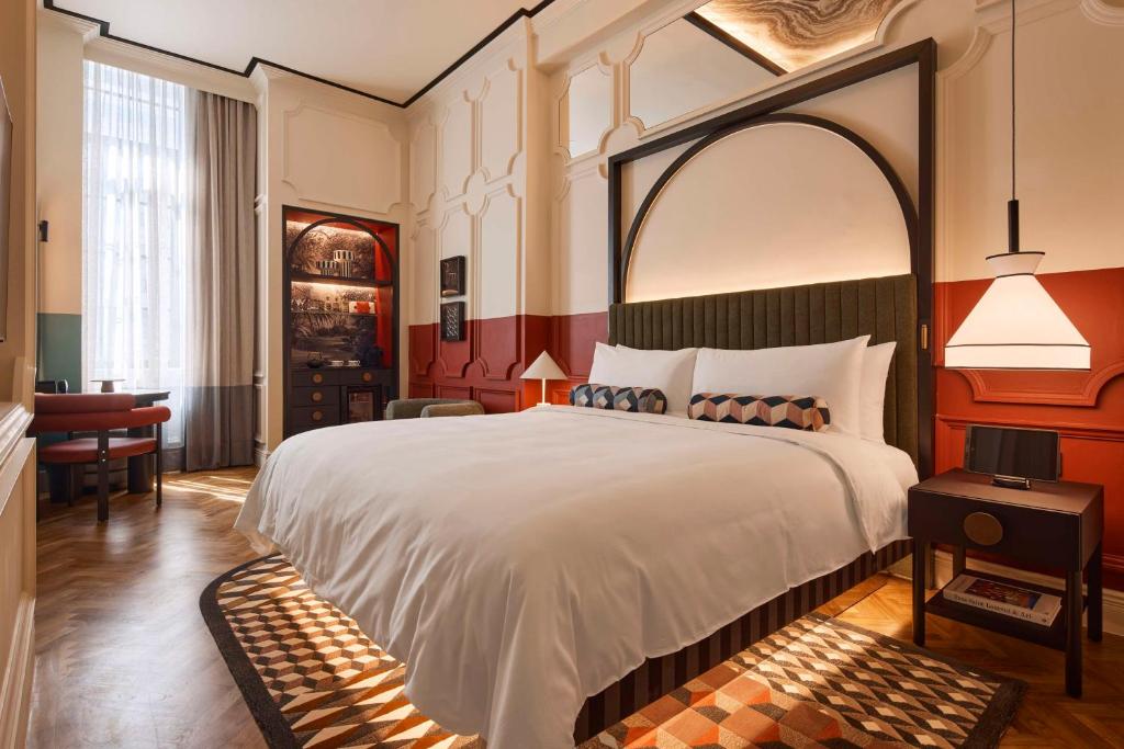 a bedroom with a large white bed with an arch above it at QT Singapore in Singapore