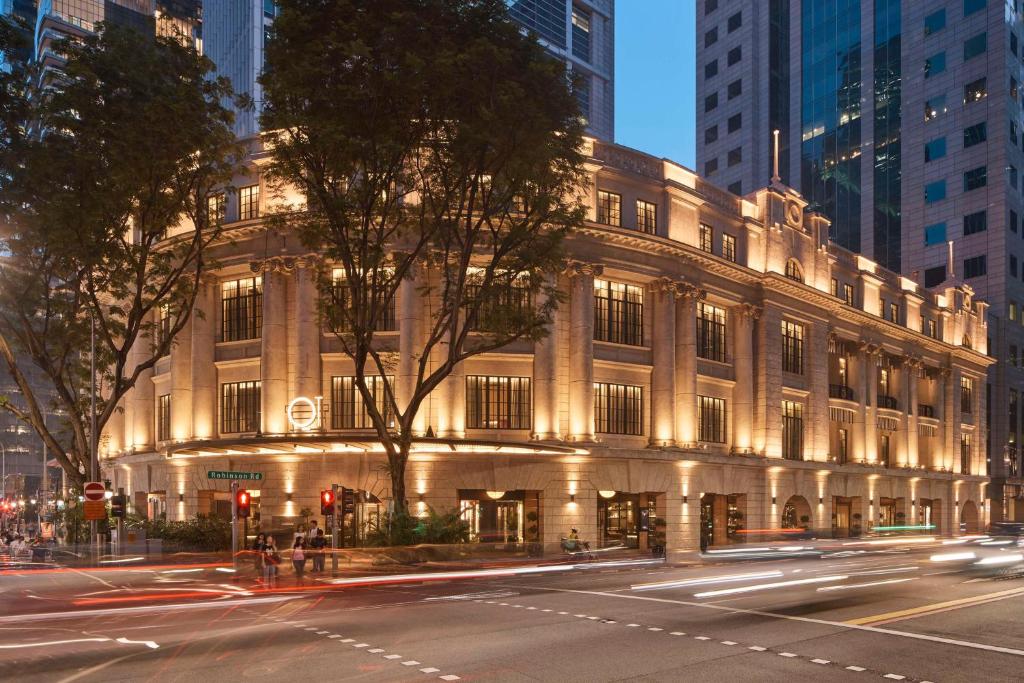 a lit up building on a city street at night at QT Singapore in Singapore