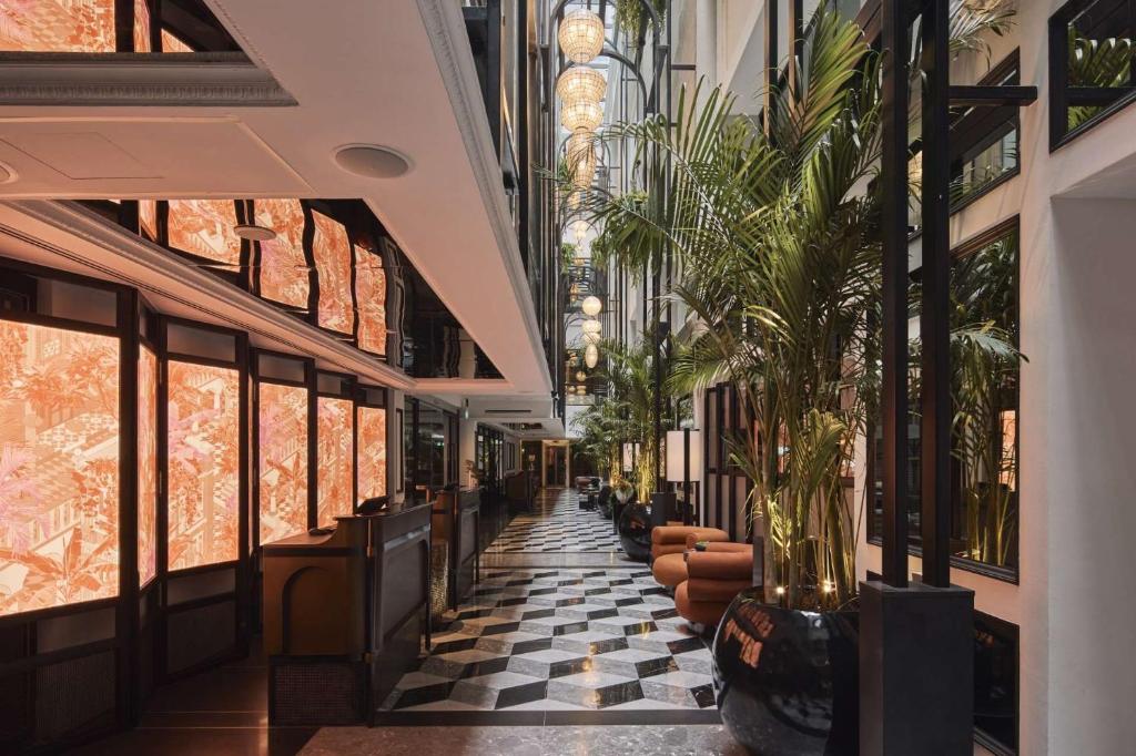 a hallway with potted plants in a building at QT Singapore in Singapore
