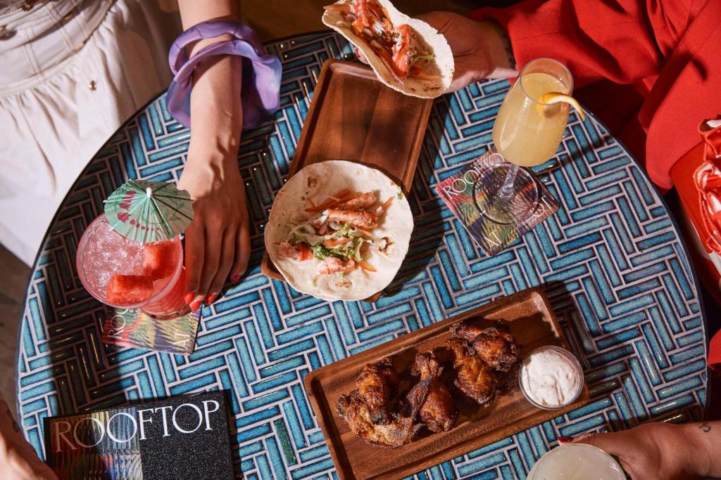 a group of people sitting at a table with food and drinks at QT Singapore in Singapore