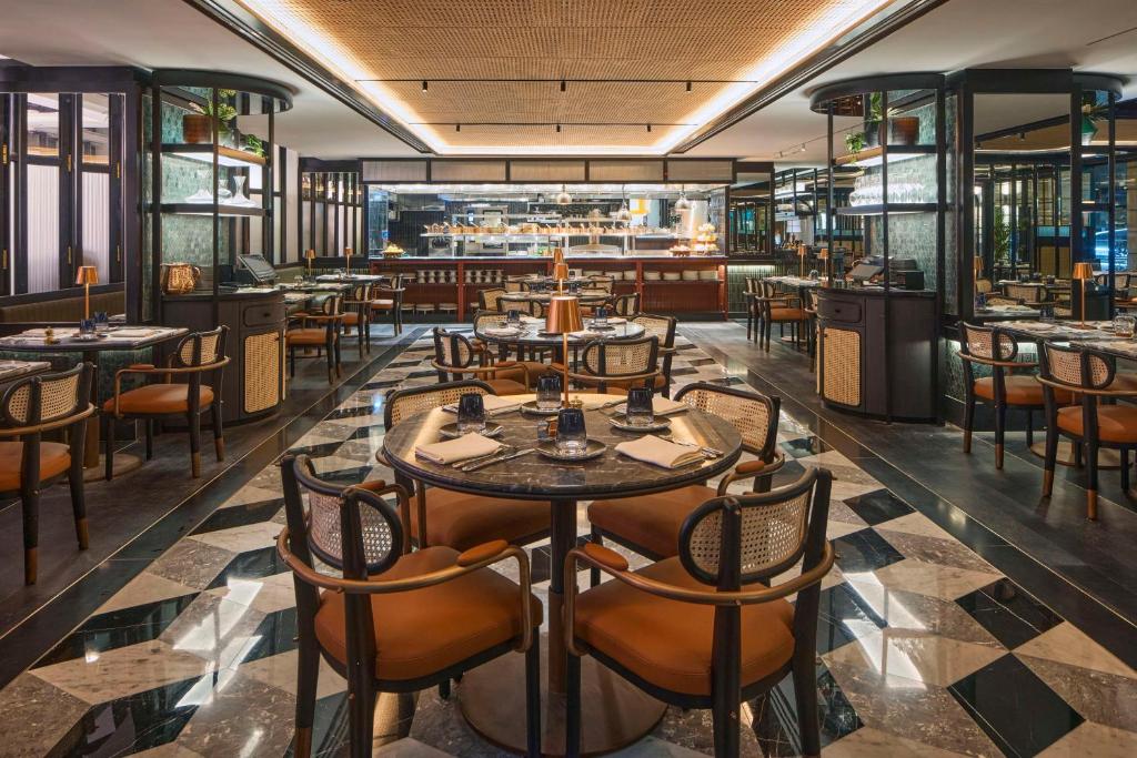a restaurant with tables and chairs and a bar at QT Singapore in Singapore
