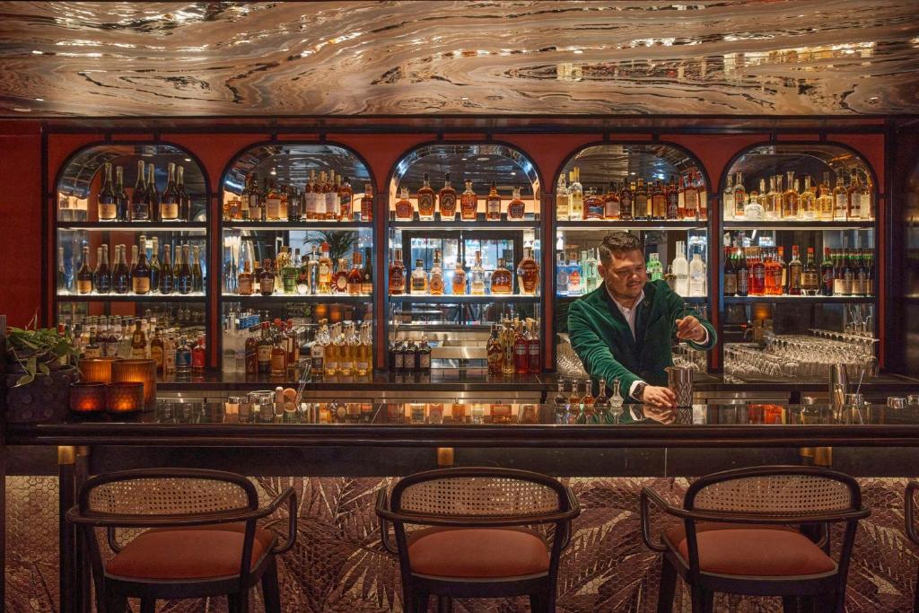 a man standing behind a bar in a pub at QT Singapore in Singapore