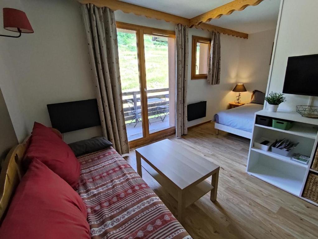 un salon avec un canapé, un lit et une télévision dans l'établissement Résidence Les Hauts De Preclaux - Appartement cosy avec vue sur les pistes MAE-7961, aux Orres