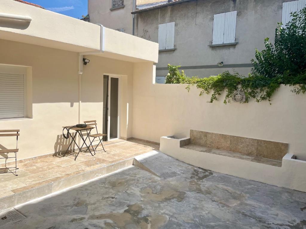 un patio d'une maison avec une table et des chaises dans l'établissement Gzenaya, à Avignon