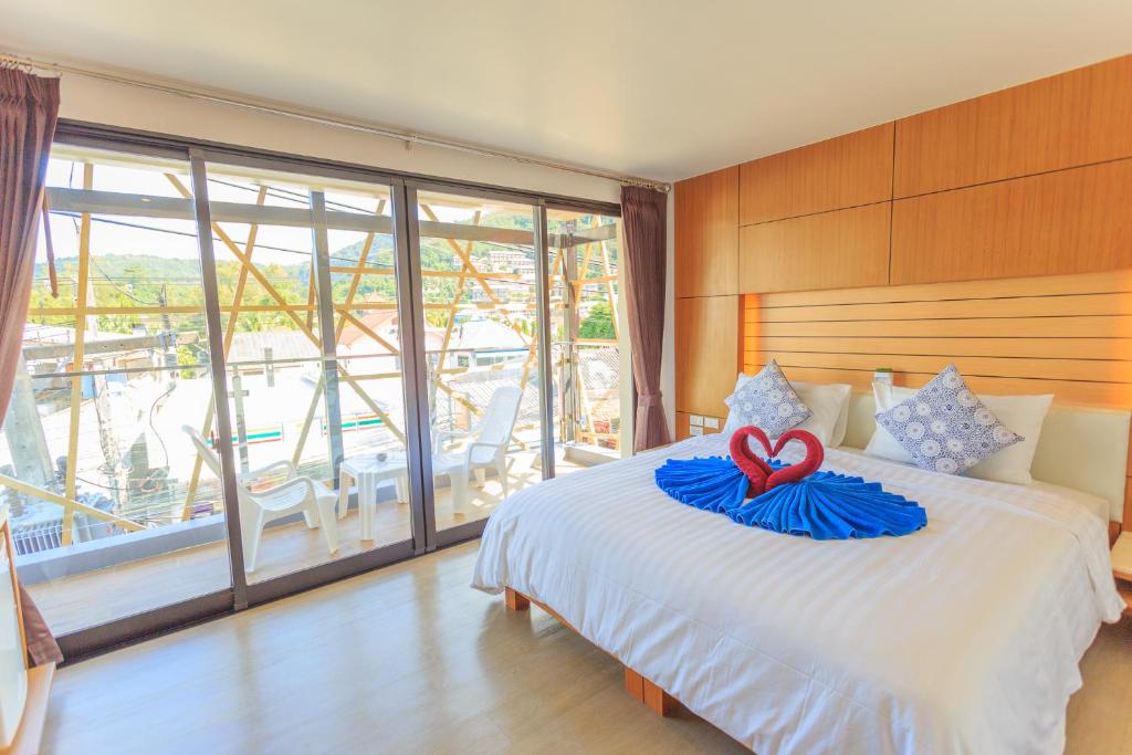 a bedroom with a bed with a heart on it at Room Actually in Karon Beach