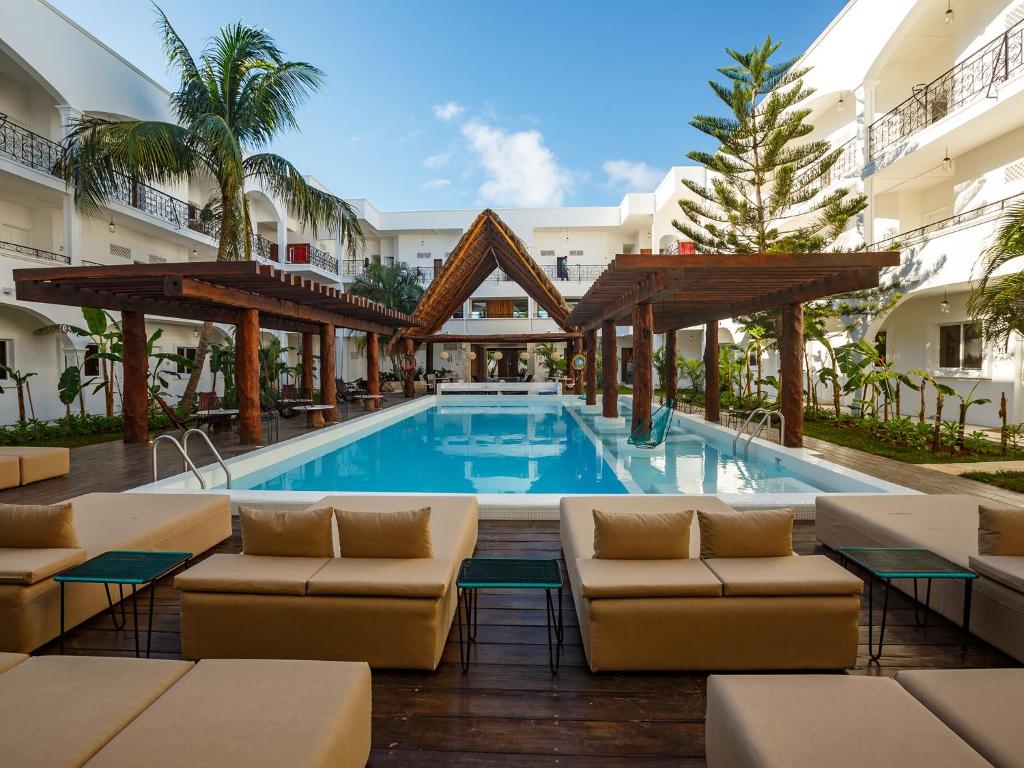 - une piscine avec des chaises longues et un complexe dans l'établissement HM Playa del Carmen, à Playa del Carmen