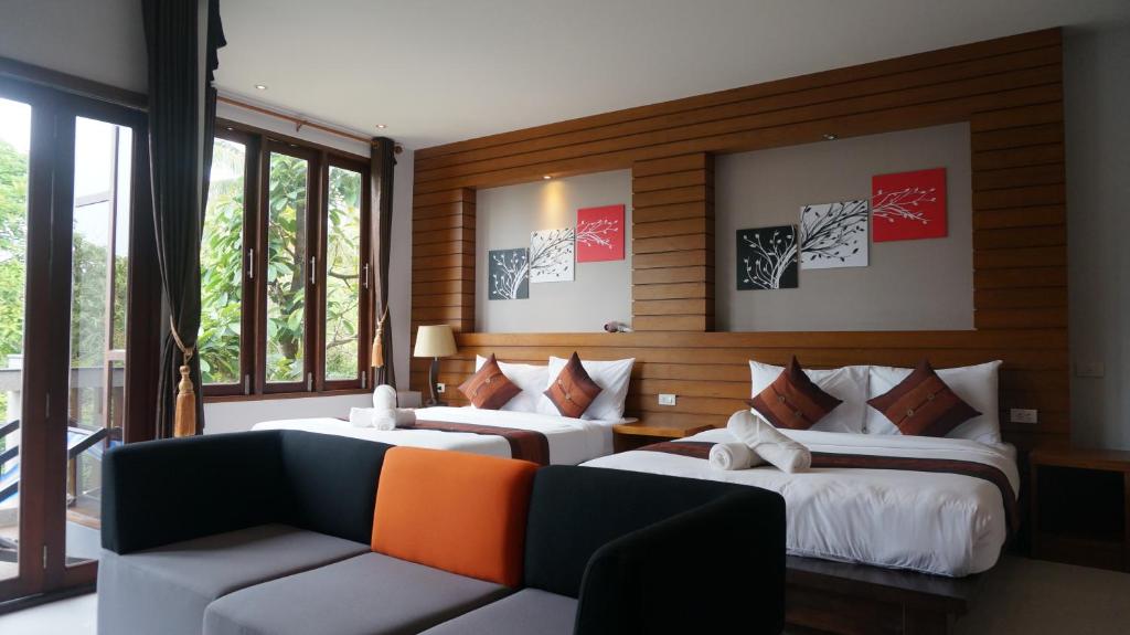 a hotel room with two beds and a couch at Lanta Intanin Resort - SHA Extra Plus in Ko Lanta