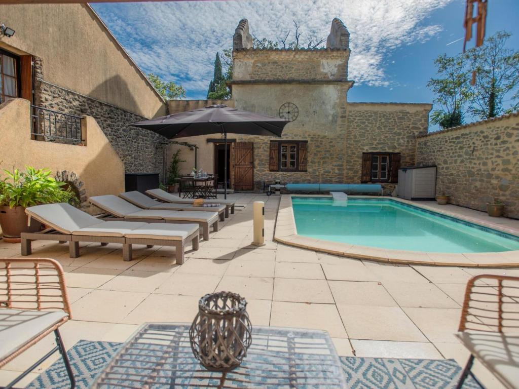- une piscine extérieure avec des chaises longues et un parasol dans l'établissement Le Pigeonnier de Villefloure, à Montréal