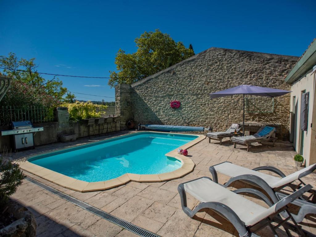 ein Schwimmbecken mit zwei Stühlen und einem Sonnenschirm in der Unterkunft Lécurie in Montréal