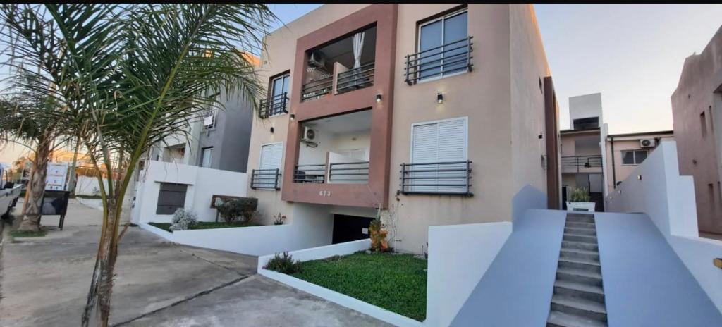 un edificio de apartamentos con escaleras y una palmera en Punto Termal - Depto 8, en Federación