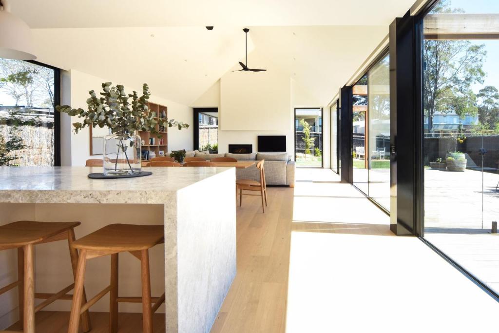 een open keuken en woonkamer met een groot kookeiland met barkrukken bij Elske on St Anns in Flinders