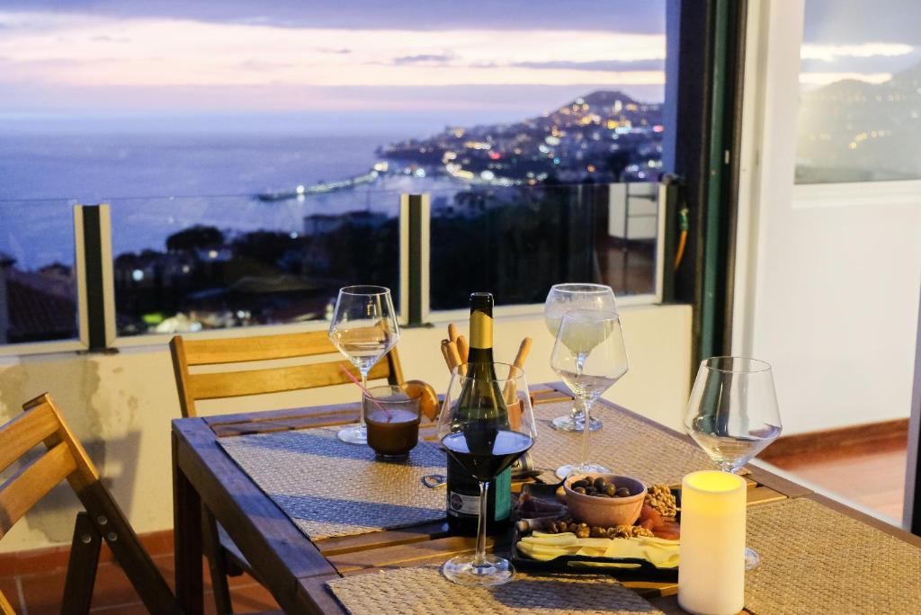 a table with wine glasses and a view of the city at Funchal Sunset Apartment in Funchal