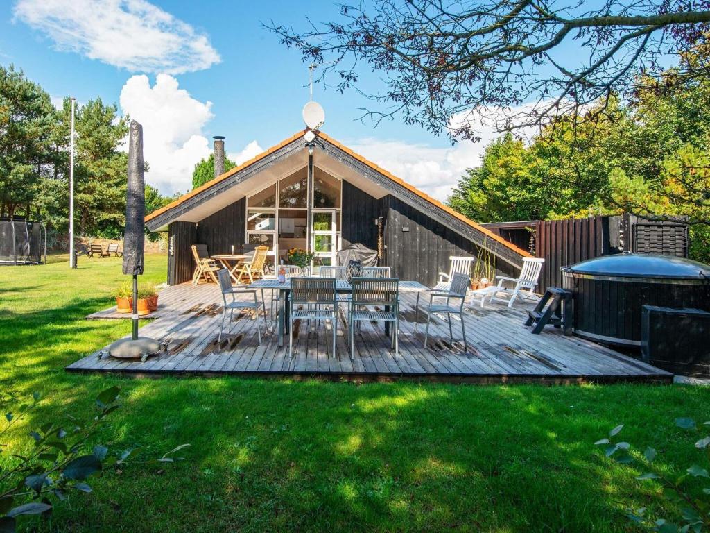 a deck with a table and chairs in a yard at 6 person holiday home in Ulfborg in Ulfborg