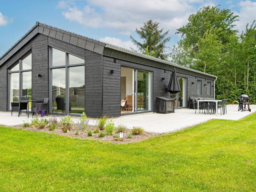 Ansagerにある10 person holiday home in Ansagerのパティオと芝生のある黒いモジュラーホーム