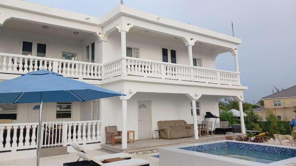 una casa bianca con piscina e ombrellone di New condo with sea view 3 a Wheeland Settlement