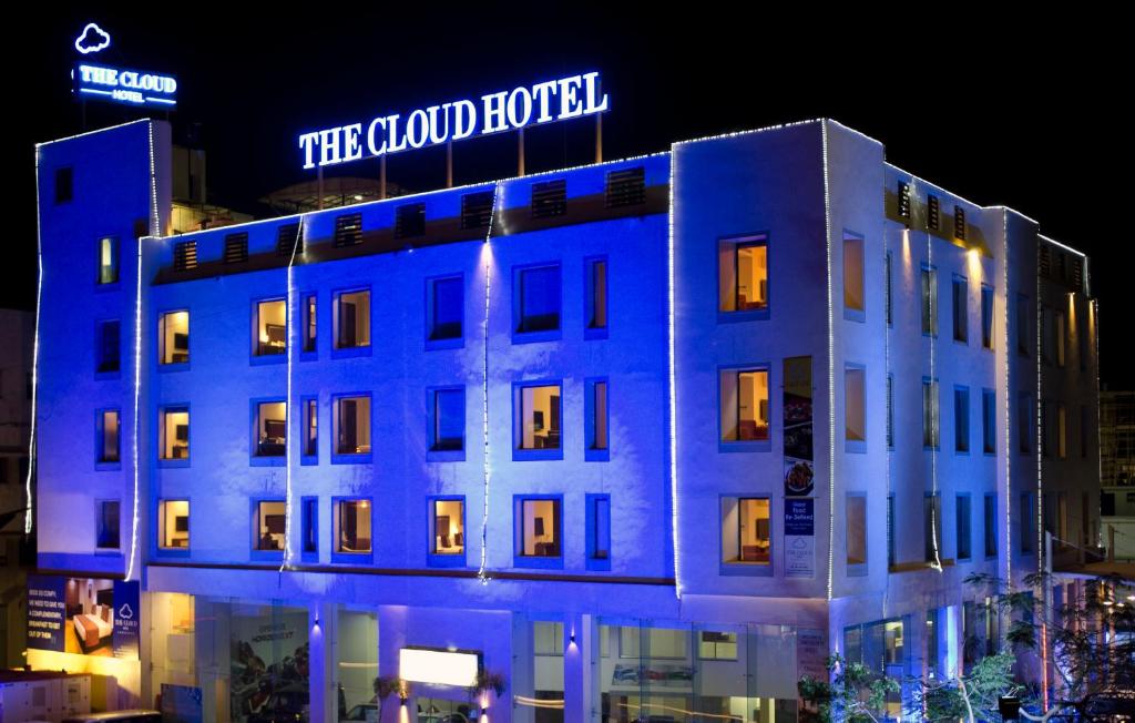 un edificio con un cartel de luz azul encima en The Cloud Hotel, en Ahmedabad