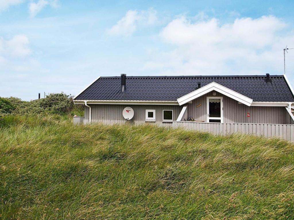 a house on top of a grassy hill at 6 person holiday home in Hjørring-By Traum in Vester Vidstrup