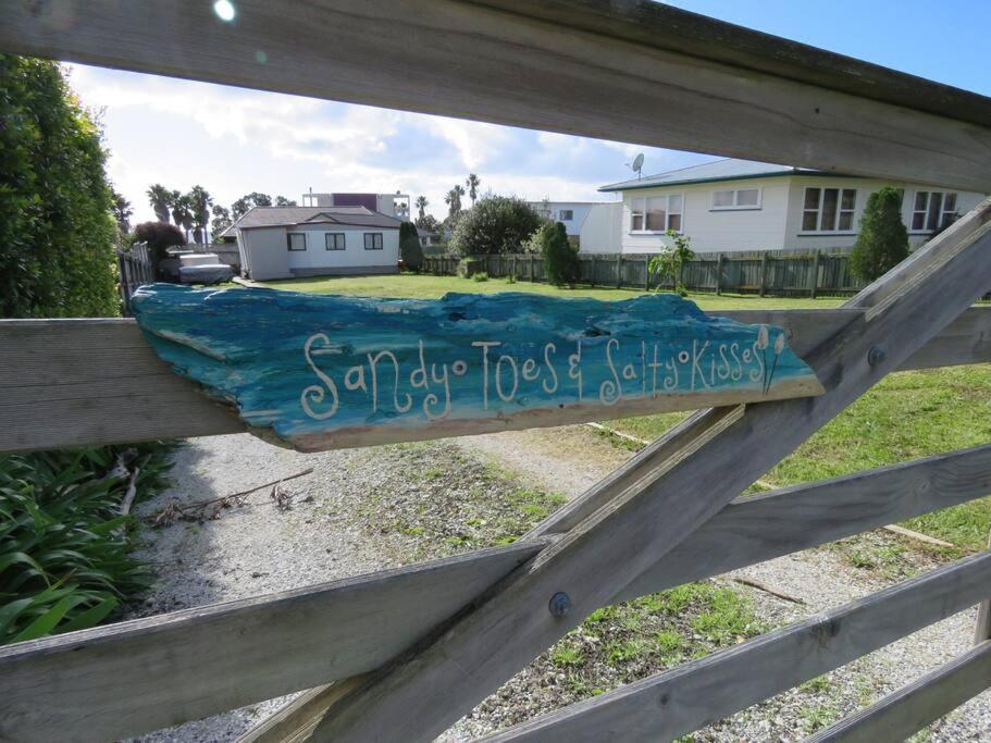 a sign on a fence with writing on it at Sandy Toes at Coopers Beach in Coopers Beach