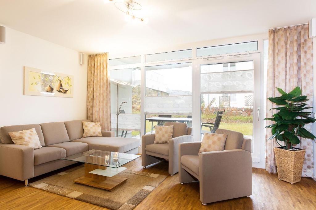 a living room with a couch and chairs and a table at Dünenresort Binz - Ferienwohnung 4.1.6 in Binz