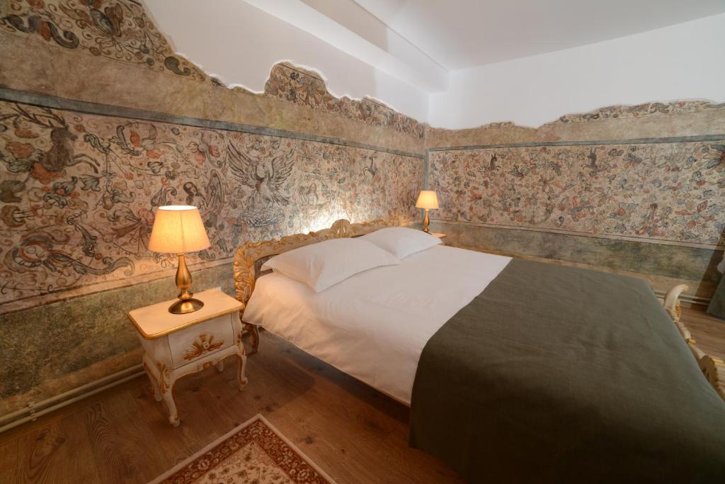 1 dormitorio con 1 cama en una habitación con papel pintado en Casa Astronomului, en Sibiu