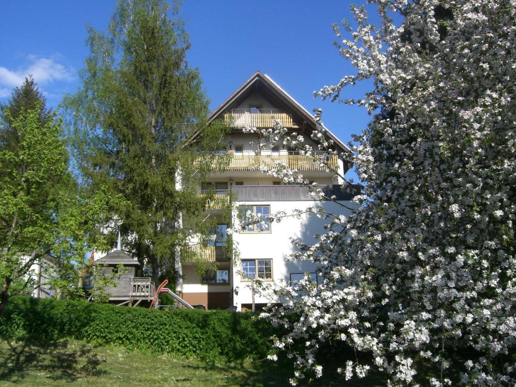 a white building with a balcony and trees at Gasthof Frankenstuben in Ebern