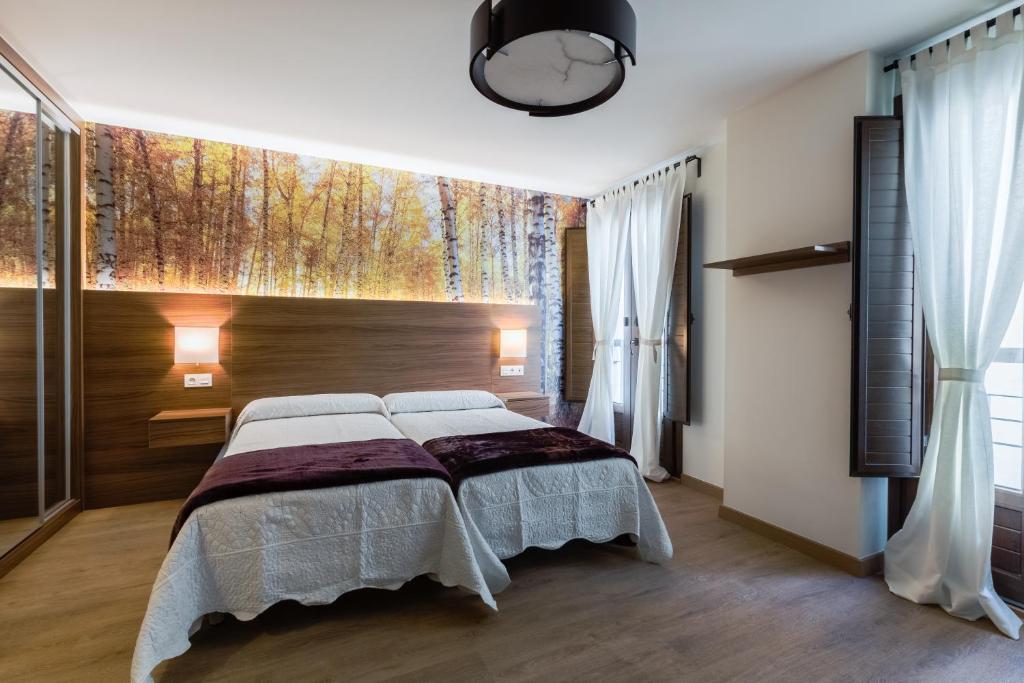 1 dormitorio con cama y ventana grande en Hostal Arriola, en Granada