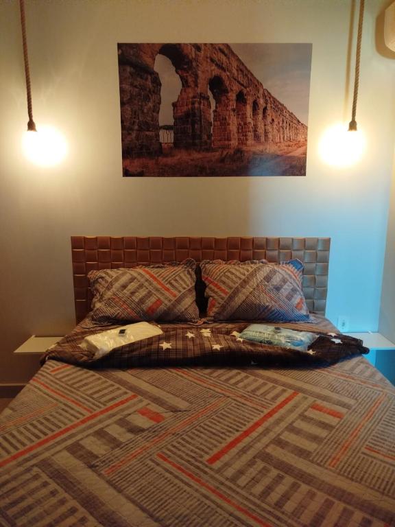 a bed with two pillows and a picture on the wall at Pousada Consulado in Brasília