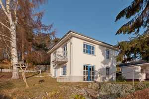 a white house with a tree in front of it at Ferienhaus Ostseeblick in Göhren