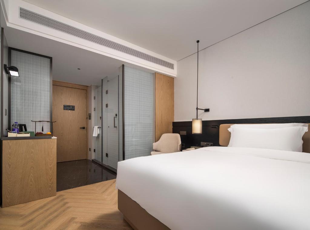 Postel nebo postele na pokoji v ubytování Mehood Lestie International Hotel Panyu Wanbo Yuangang Metro Station Branch - Free Shuttle Bus to Canton Fair Complex During Canton Fair Period & Free afternoon tea & Free midnight snack & Free VPN Internet Access