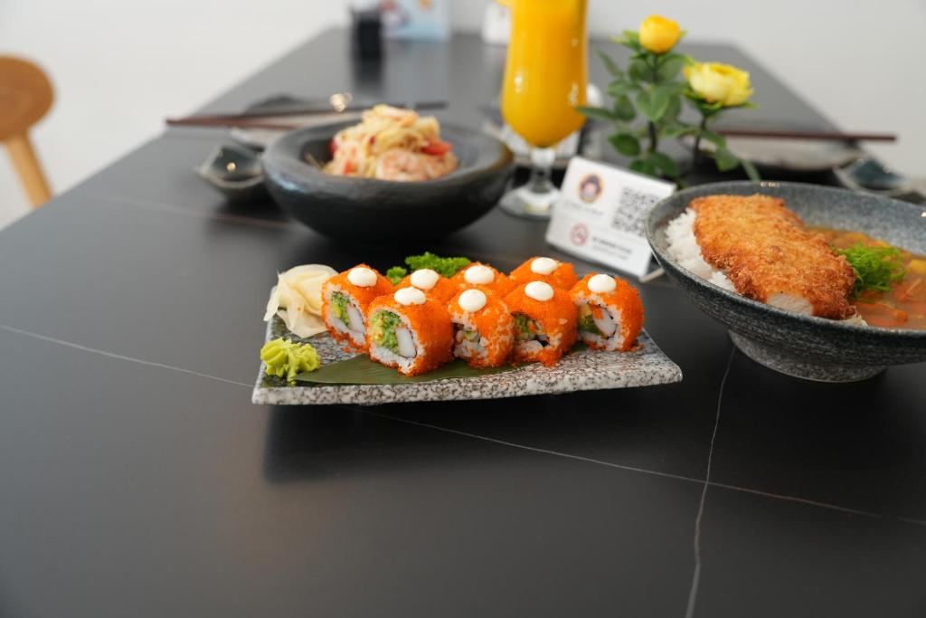 a table with two plates of sushi and bowls of food at AG Hotel in Abu Dhabi