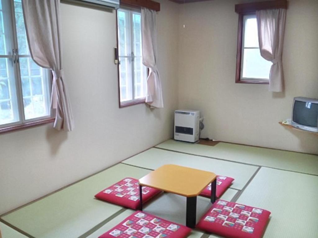 a room with a table and two red mats at Pension Come Tatami-room with a calm atmosphere - Vacation STAY 14983 in Minami Uonuma