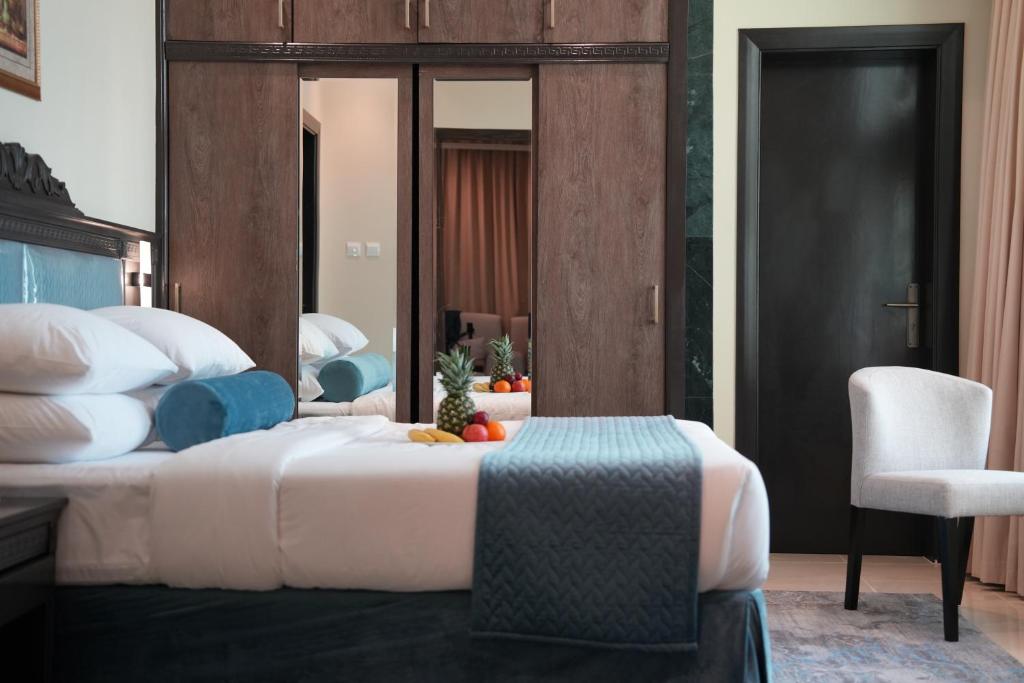 a bedroom with a large bed and a chair at AG Hotel in Abu Dhabi