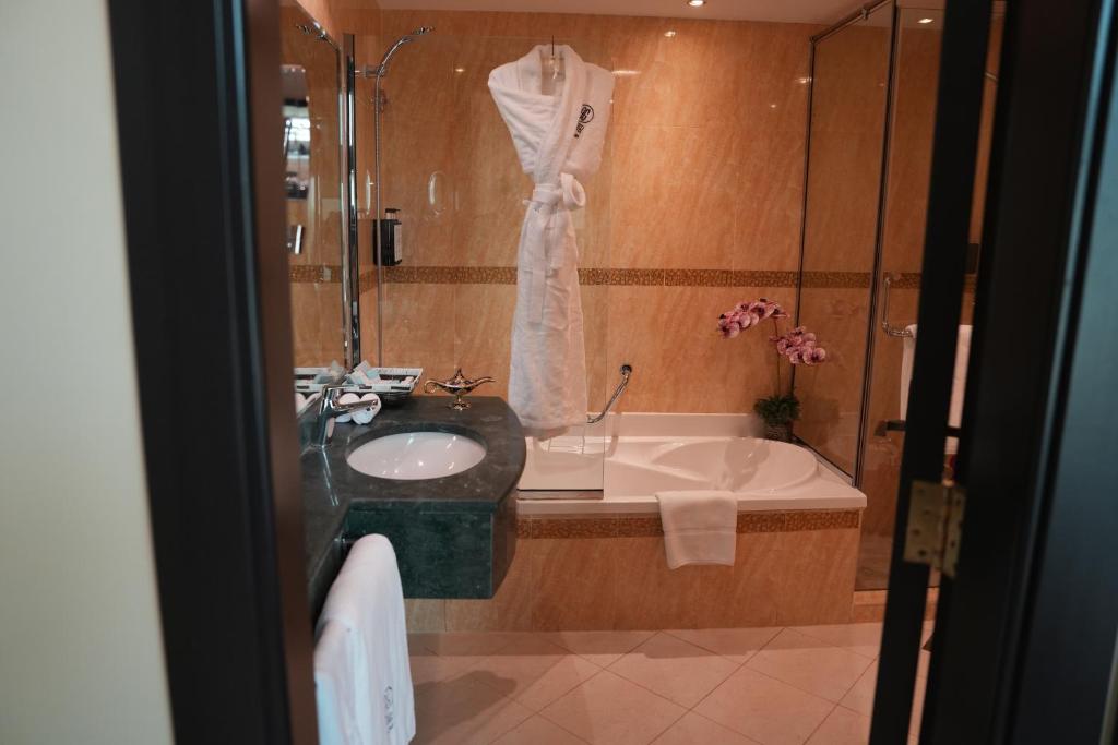 a bathroom with a sink and a bath tub at AG Hotel in Abu Dhabi