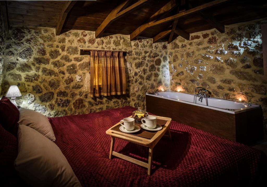 um quarto com uma banheira e uma mesa com teaitures em Paliokastro Guesthouse em Kato Trikala Korinthias