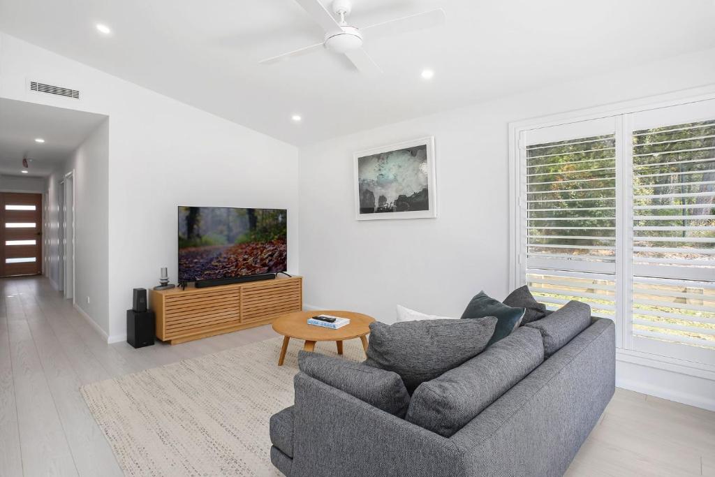 a living room with a couch and a table at Clovelly - Book 3 nights, pay for 2! in St Georges Basin