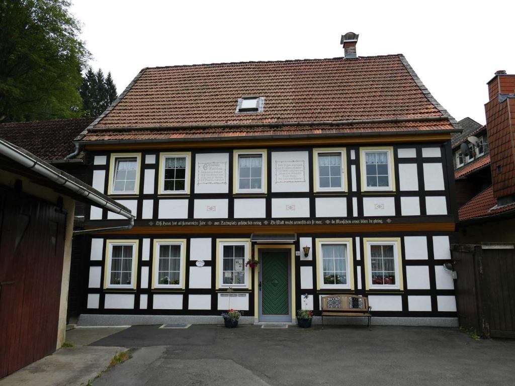 a black and white building with a green door at Silvias Ferienwohnung - Bohlweg 43 in Wildemann