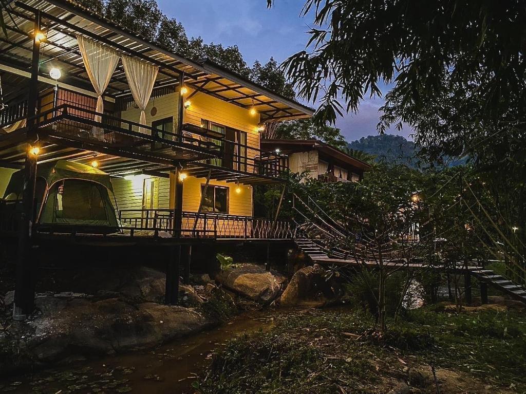 a house with a staircase leading up to it at บ้านชมธาร บ้านสวนสราญชล in Ban Plai Nam (2)
