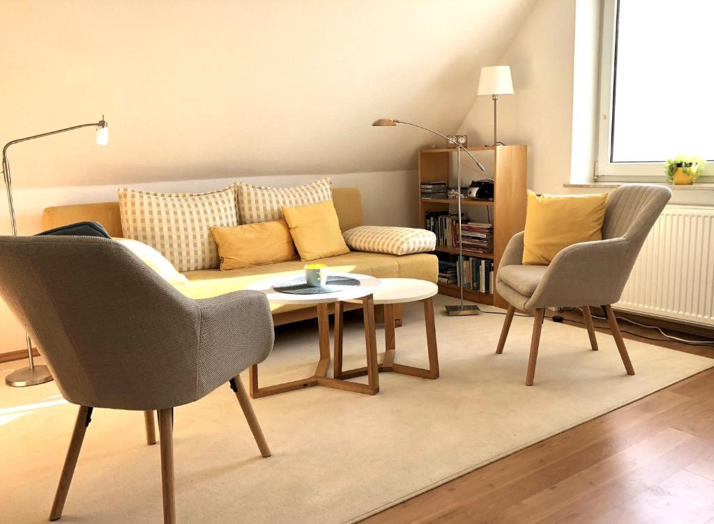 a living room with a couch and a table and chairs at Ferienwohnung am Seezeichen in Böhl