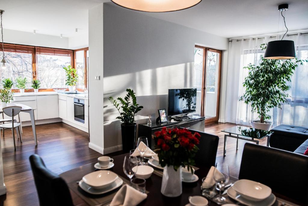 a living room with a table and a kitchen at Apartment Extra Home in Kielce
