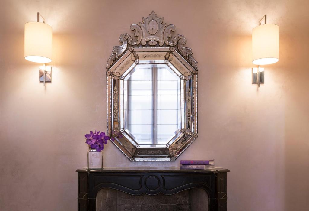 a mirror on a wall above a table with a window at Magda Champs Elysées in Paris