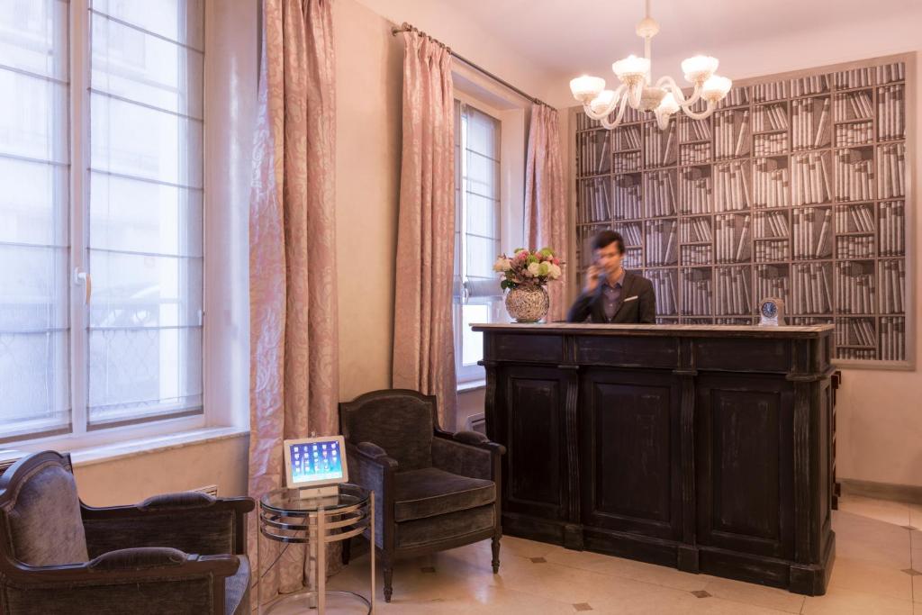 a man sitting at a bar in a room with chairs at Magda Champs Elysées in Paris