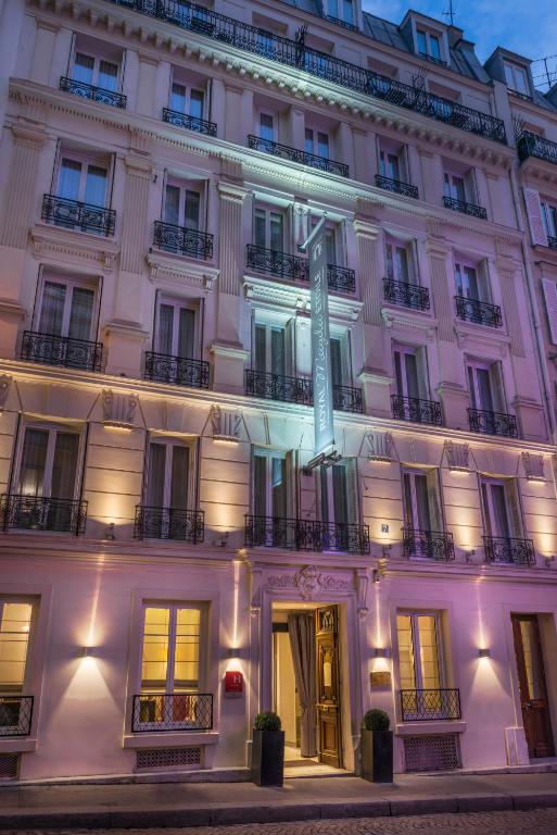 a large white building with a statue in front of it at Magda Champs Elysées in Paris